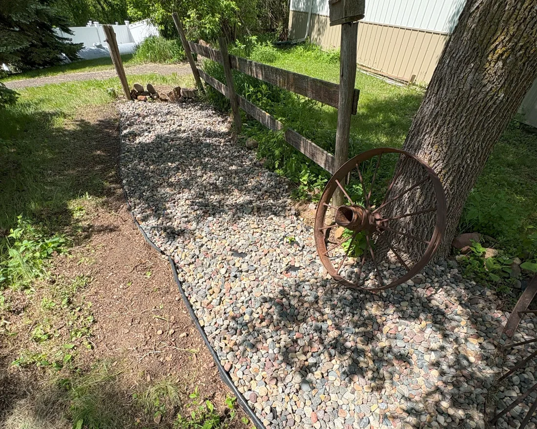 Decorative rock bed along fence